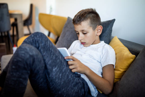 istock Young boy is playing games on his tablet at home 1181444080