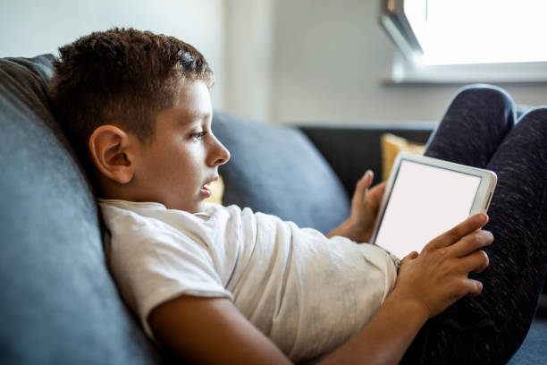 istock Young boy is playing games on his tablet at home 1181445238