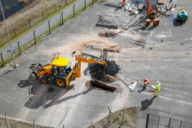 Road Works - Construction workers repairing the asphalt surface and drainage. stock photo