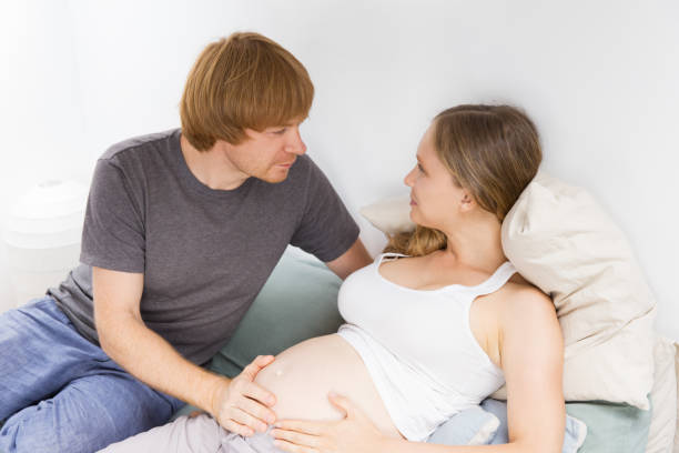 istock Happy expectant couple relaxing at home 1181445468