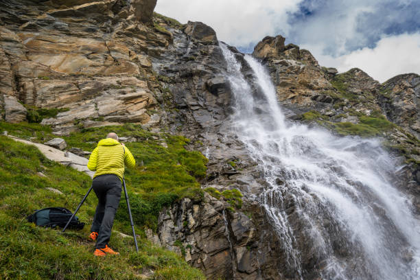 landschaftsfotograf fotografiert wasserfall in den bergen - behind photographer men mountain climbing stock-fotos und bilder