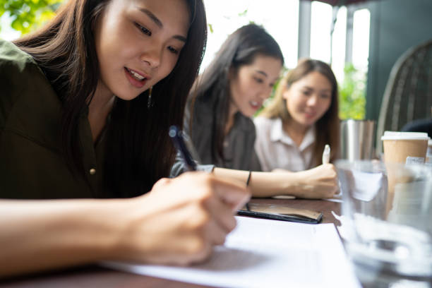 istock Asian women sitting in cafe and writing plans in notepad 1181446532