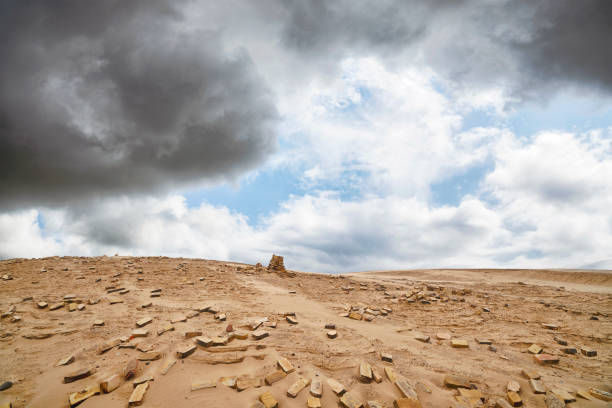 Bricks in a dry desert in cloudy weather with a stack of stones