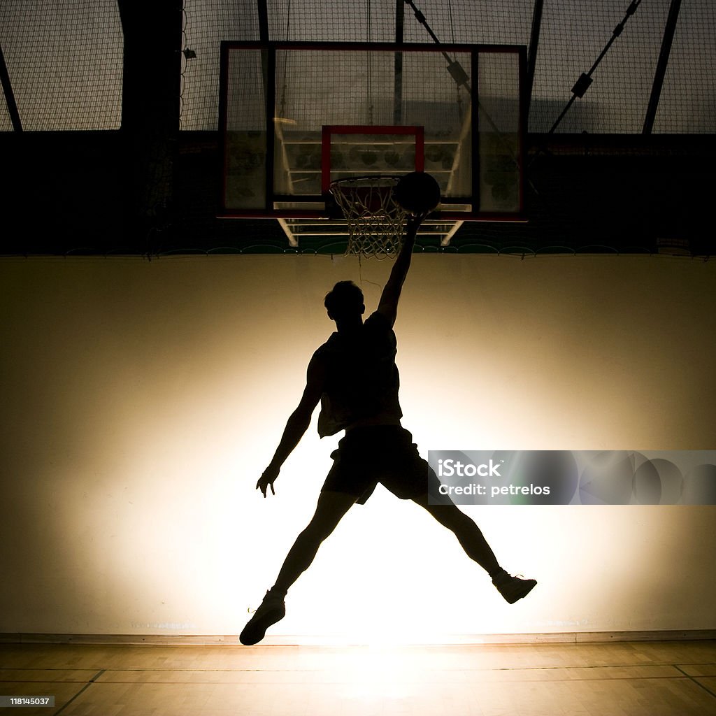 バスケットボール選手ジャンプ、ボール、バックライト付き - カラー画像のロイヤリティフリーストックフォト
