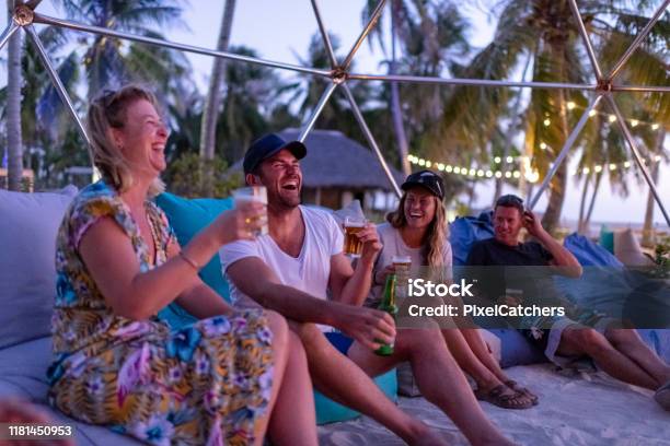 해질녘 해변에서 모닥불 주위를 웃고 있는 친구들 해변에 대한 스톡 사진 및 기타 이미지 - 해변, 해변 파티, 파티