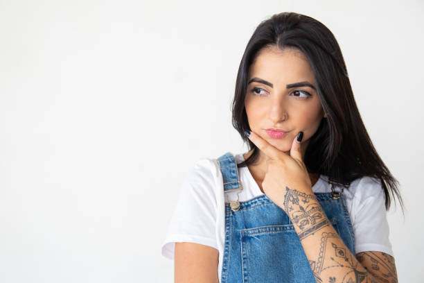 istock Thoughtful woman wearing denim jumpsuit looking aside 1181452679
