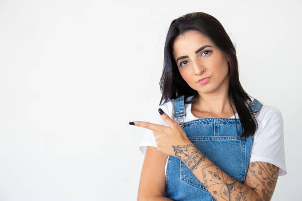 istock Calm young woman pointing to left with finger 1181455218