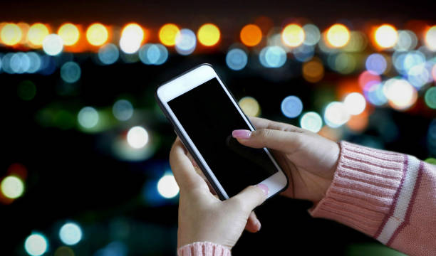 istock female using smart phone in night cityscape 1181455521
