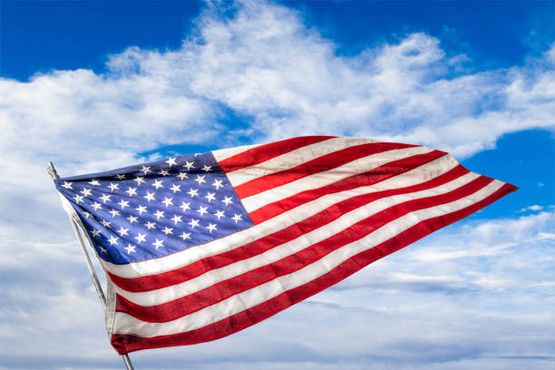 istock USA Flag Waving Against Blue Cloudy Sky Background With Copy Space 1181455795