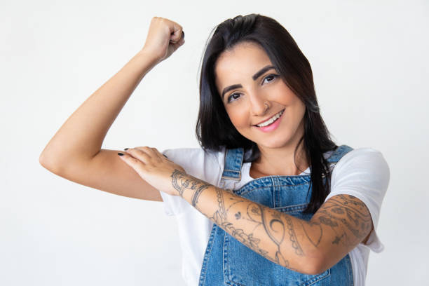 istock Smiling young woman showing muscles 1181456859
