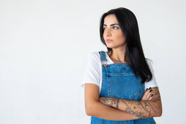 istock Serious young brunette with crossed arms looking aside 1181456923