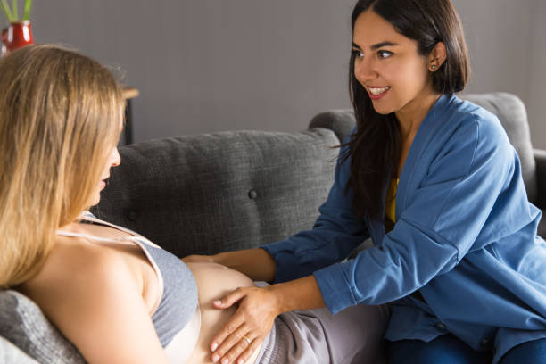 parteira que examina a matriz expectante em casa - midwife human pregnancy women multi ethnic group - fotografias e filmes do acervo