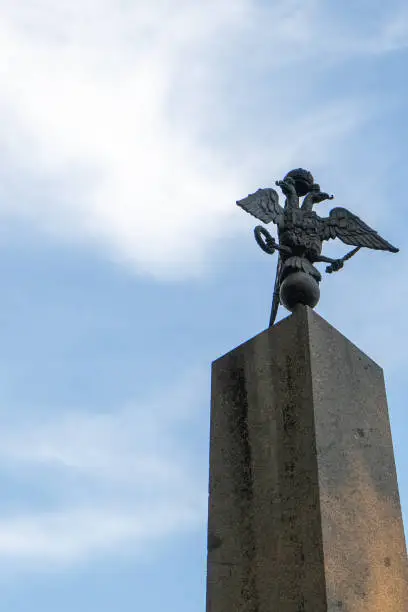 Photo of Bronze double-headed eagle on a monument in a city park. Uman. Ukraine.