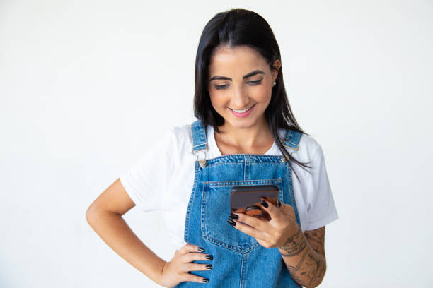 istock Front view of smiling young woman using smartphone 1181463040