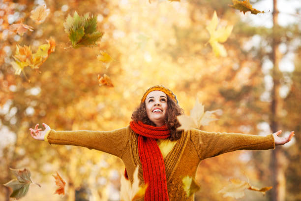 istock Cheerful girl catching autumn leafs 1181463293