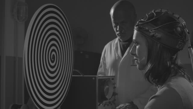 Scientist hypnotizing a woman in a scientific lab