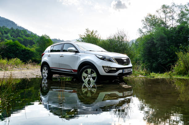 kia sportage 2.0 crdi awd oder 4x4, weiße farbe, überquerung eines sees lazici, auf dem berg tara, in der nähe einer großen klippe, und schöne landschaft, in tiefen schlamm rad spin, große off-road - editorial sports utility vehicle car jeep stock-fotos und bilder