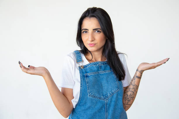 istock Doubting woman with raised hands looking at camera 1181464671