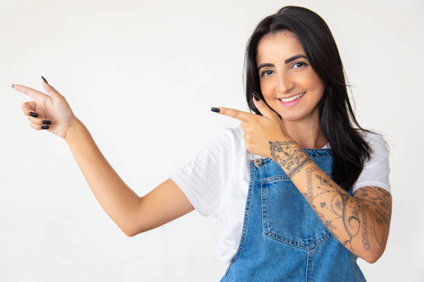 istock Smiling young brunette pointing to left 1181465007