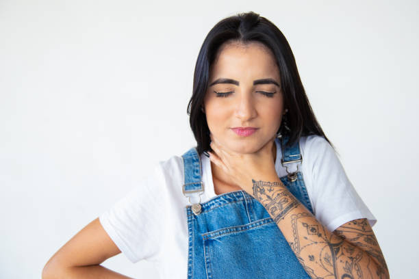 istock Sick young woman holding hand on throat 1181465686