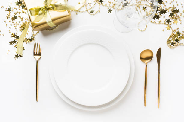 istock Christmas table setting with golden dishware, silverware on white background. Top view. 1181468586