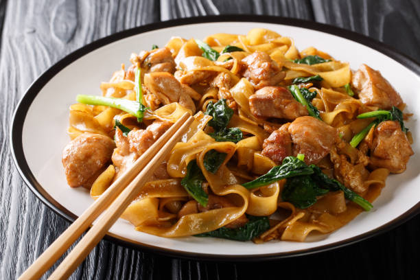 istock Fried rice noodles with chicken, Chinese broccoli and egg close-up on a plate. horizontal 1181468593