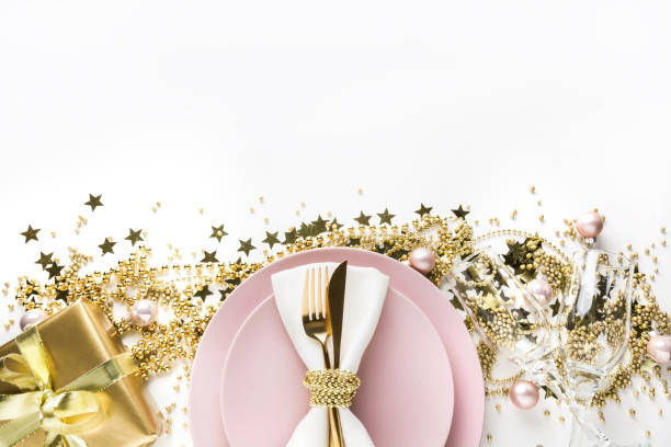 istock Christmas table setting with pink dishware, golden silverware on white background. Top view. 1181469002