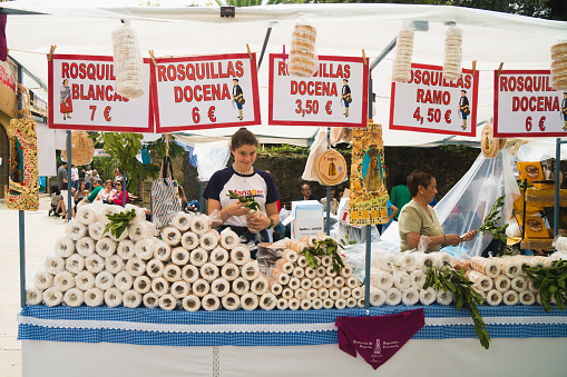 Bilbao, Spain - August 15 2019: Girl selling traditional biscuit cakes from Basque county close to the Basilica of Begona, in north of Spain