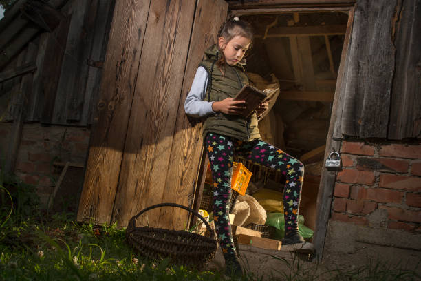 istock Girl in the barn reading a book. 1181470113