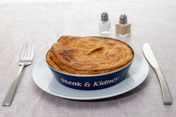 A savoury steak and kidney pie with a pastry crust cooked and in its tin can.