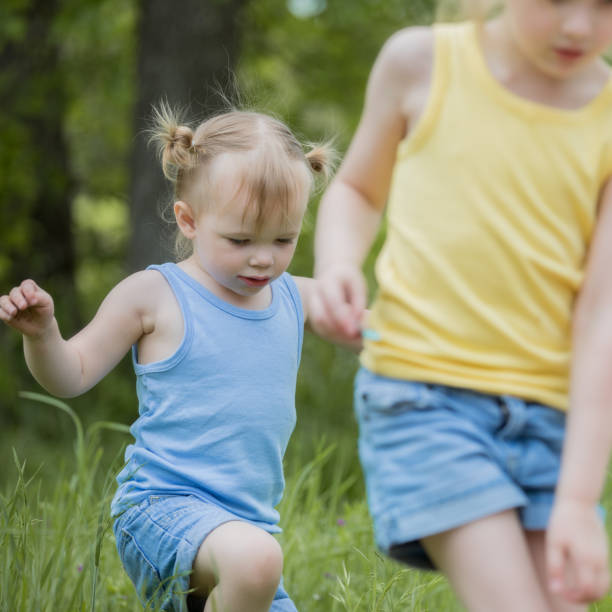 istock Female siblings walking through field 1181471728