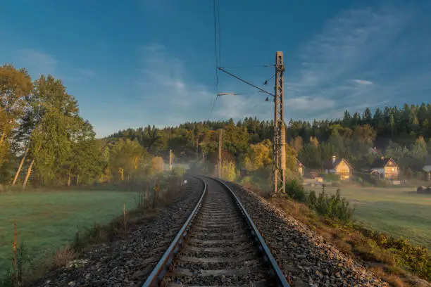 Electric railway track in color morning with fog and autumn color fresh air