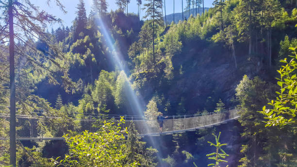 istock Schladming - Man walking on a suspension bridge 1181479352