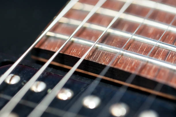 istock guitar  with wooden brown neck and strings, close up blurry background, texture, abstract 1181480391