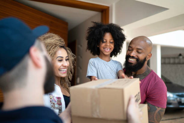 Family receiving a delivery from the mailman Family receiving a delivery from the mailman receiving box stock pictures, royalty-free photos & images