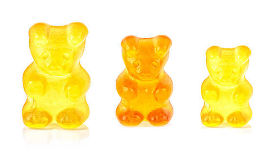 Colored fruit gummy candy in the form of a bear, white background. Jelly bean.