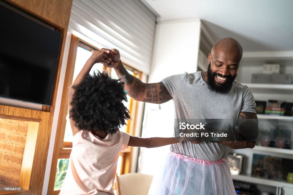 Funny father with tutu skirts dancing like ballerinas Father Stock Photo
