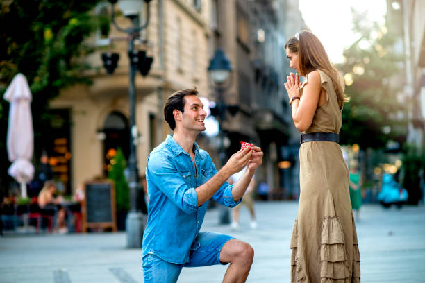 Young man proposing to a woman stock photo