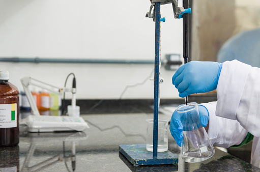 Using a pipette, the scientist accurately measures the solution he inserts into the laboratory glassware.