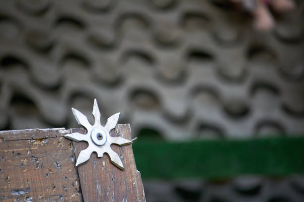 Close up throwing board for throwing star decorated with broken shurikens, selective focus