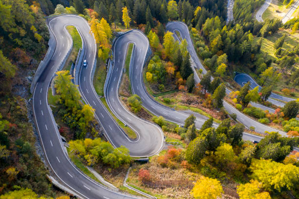 Winding Mountain Road, Maloja Pass, Swiss Alps Aerial view of Maloja Pass in autumn, Graubunden Canton, Switzerland. drone point of view road stock pictures, royalty-free photos & images
