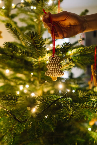 istock Female hand hangs a gingerbread snowflake on the Christmas tree 1181498620