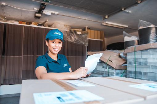 Mixed race woman checking the delivery receipt in the warehouse