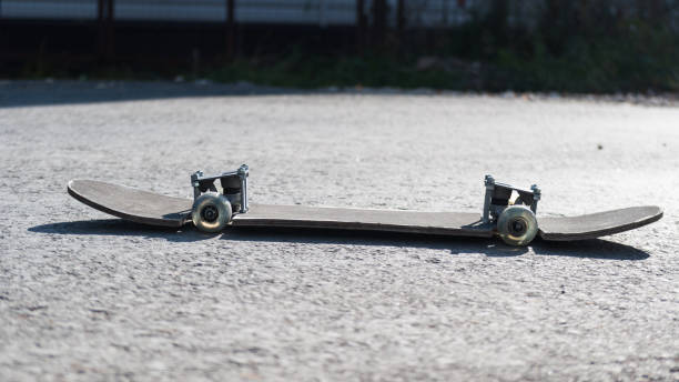 istock stylish skateboard on asphalt road. redone and understated. a battered old wench with a skinned head. old school style. Sunny autumn day with skateboard. skateboard style. lifestyle on the Board. 1181499838