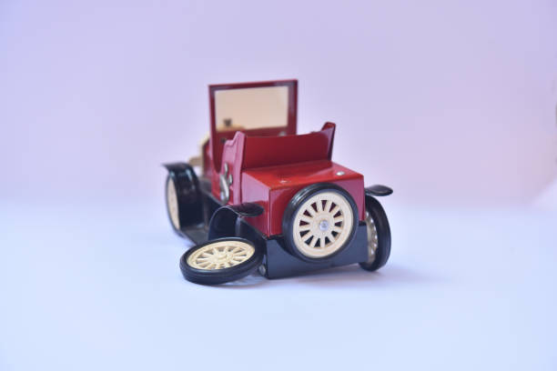 istock Small red antique toy car with a broken wheel 1181500097