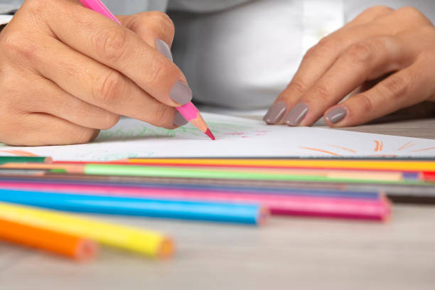 istock woman's hand in the office draws with crayons on paper 1181500172