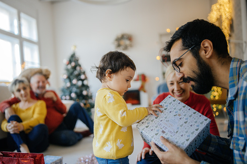 Photo of happy family opening presents on Christmas day