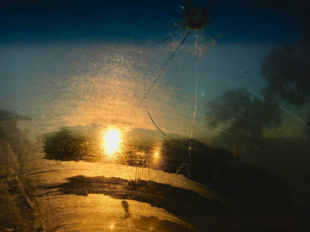 soleil de lever de soleil brillant par le pare-brise cassé givré dans le colorado occidental - bullet hole glass window broken photos et images de collection