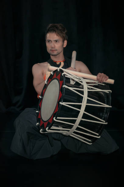 istock Japanese Taiko drummer with drum on a stage on a black background. 1181506109