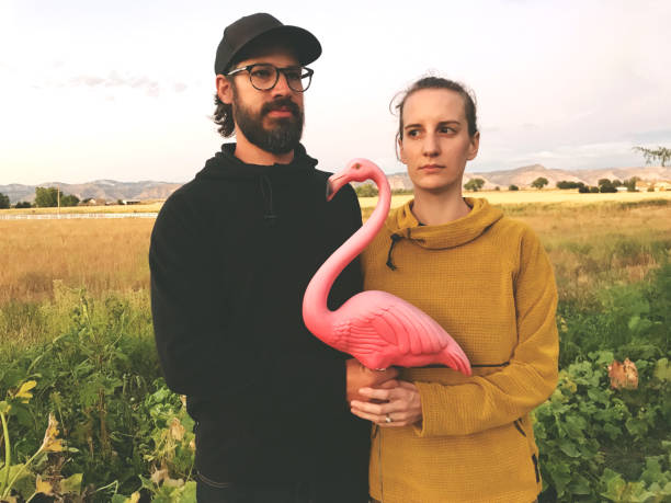 jeune beau couple millénaire mari et femme mari et femme posant avec des accessoires dans le cadre rural dans le colorado occidental - offbeat photos et images de collection